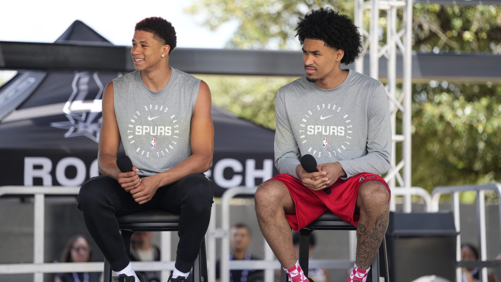 Jun 28, 2025; San Antonio, TX, USA; San Antonio first round draft picks Carter Bryant (left) and Dylan Harper answer questions during the Spurs Family Cookout at Victory Capital Performance Center.