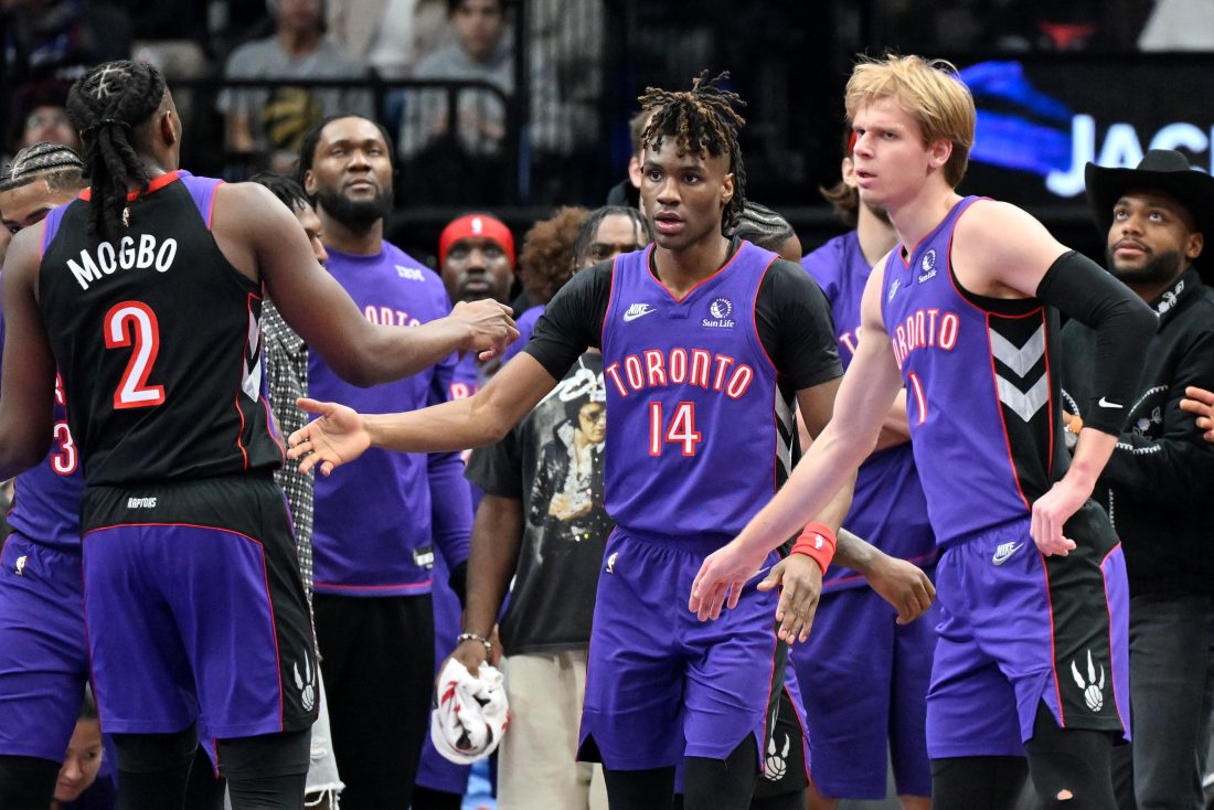 Dec 19, 2024; Toronto, Ontario, CAN; Toronto Raptors guard Ja'Kobe Walter (14) is greeted by forward Jonathan Mogbo (2) and forward Gradey Dick (1) after making a three point basket against the Brooklyn Nets in the first half at Scotiabank Arena. Mandatory Credit: Dan Hamilton-Imagn Images