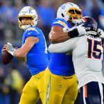 Dec 19, 2024; Inglewood, California, USA; Los Angeles Chargers quarterback Justin Herbert (10) drops back to pass as offensive tackle Rashawn Slater (70) provides coverage against Denver Broncos linebacker Nik Bonitto (15) during the second half at SoFi Stadium. Mandatory Credit: Gary A. Vasquez-Imagn Images