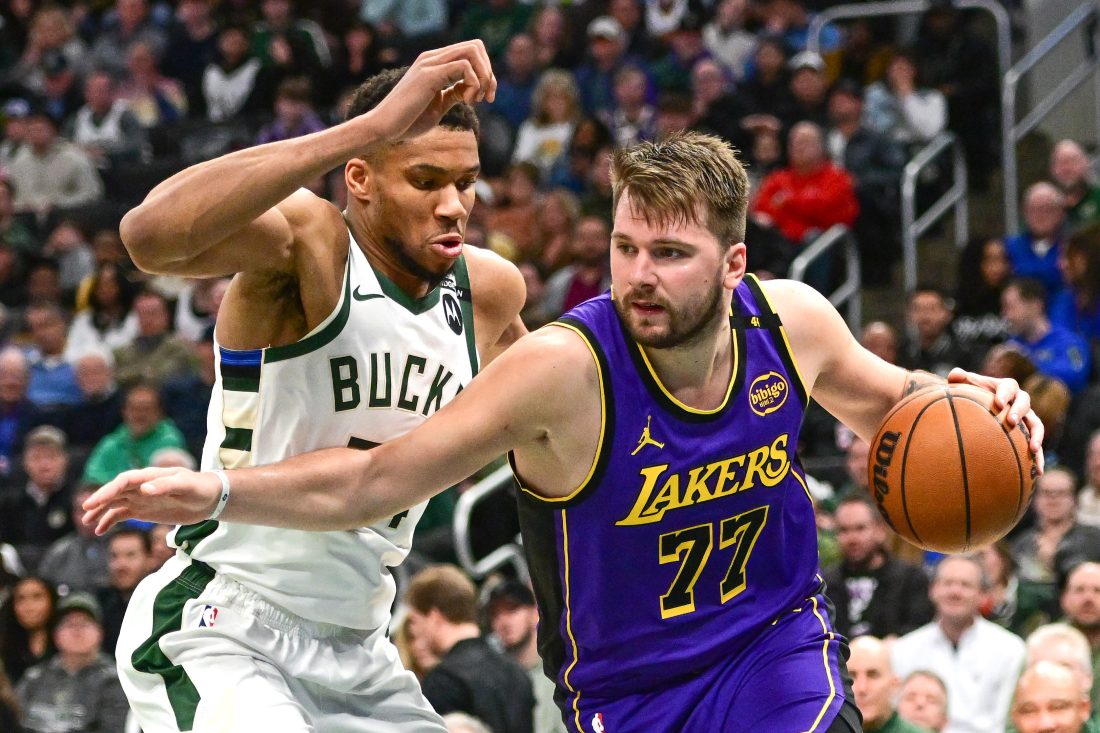 Mar 13, 2025; Milwaukee, Wisconsin, USA; Los Angeles Lakers guard Luka Doncic (77) drives to the basket against Milwaukee Bucks forward Giannis Antetokounmpo (34) in the third quarter at Fiserv Forum.