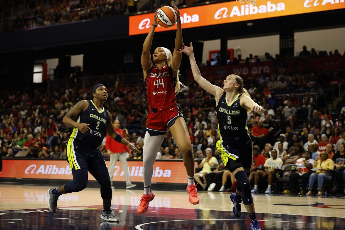 Jun 22, 2025; Washington, District of Columbia, USA; Washington Mystics forward Kiki Iriafen (44) catches a long pass as Dallas Wings guard Paige Bueckers (5) and Wings forward Myisha Hines-Allen (2) defend in the second half at Entertainment & Sports Arena. Mandatory Credit: Geoff Burke-Imagn Images