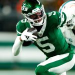 New York Jets wide receiver Garrett Wilson (5) runs with the ball past Miami Dolphins cornerback Jalen Ramsey (5), Sunday January 5, 2025, in East Rutherford.