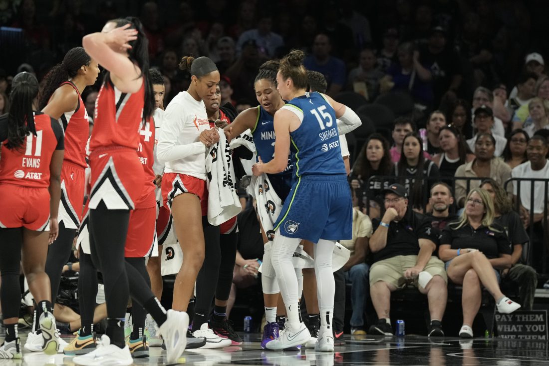 Aug 2, 2025; Las Vegas, Nevada, USA; Players from the Las Vegas Aces and Minnesota Lynx surround Lynx forward Napheesa Collier (24) after she does down with an injury in the third quarter of their game at Michelob Ultra Arena.