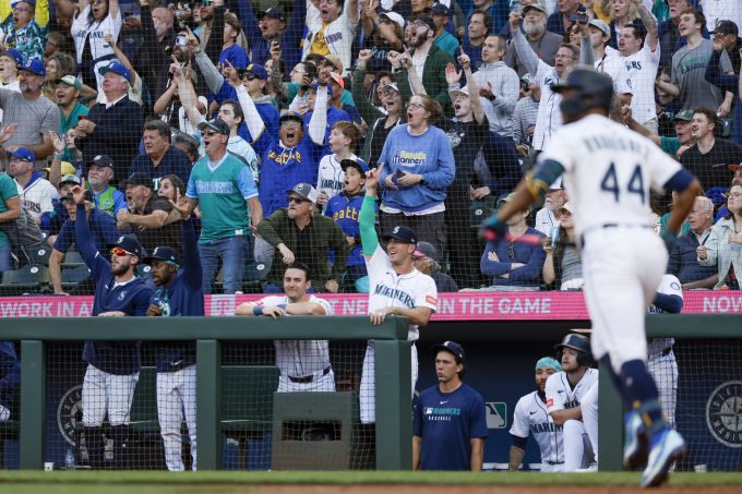 Aug 6, 2025; Seattle, Washington, USA; Fans and Seattle Mariners players in the dugout cheer following a three-run home run by center fielder Julio Rodríguez (44) against the Chicago White Sox during the second inning at T-Mobile Park. Mandatory Credit: Joe Nicholson-Imagn Images