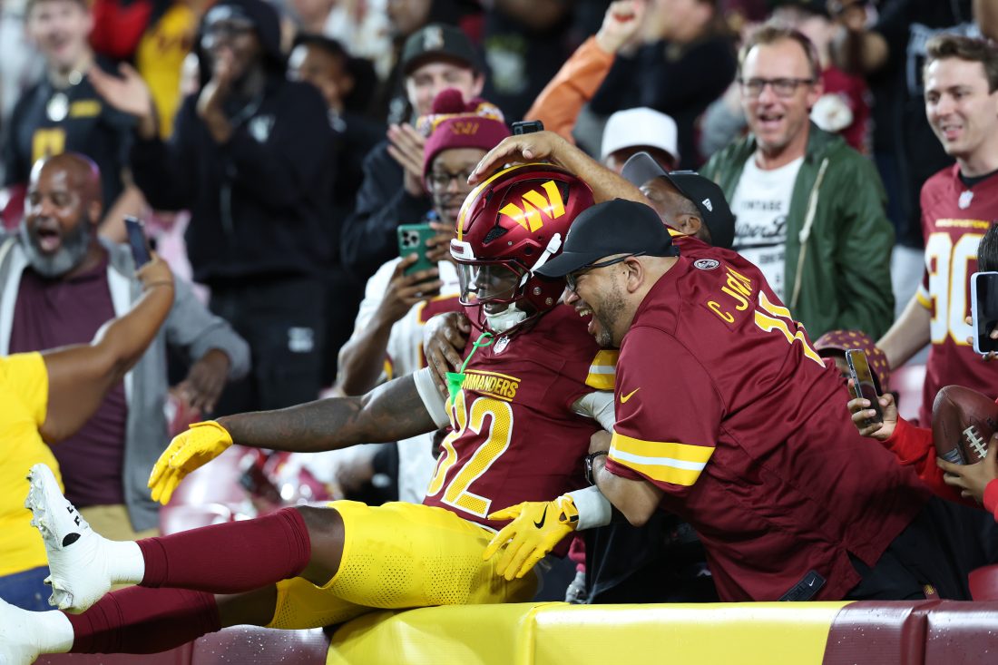 Aug 18, 2025; Landover, Maryland, USA; Washington Commanders running back Jacory Croskey-Merritt (32) celebrates with fans in the stands after scoring a touchdown against Cincinnati Bengals during the first half at Northwest Stadium. Mandatory Credit: Amber Searls-Imagn Images