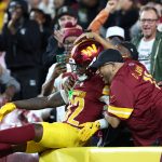 Aug 18, 2025; Landover, Maryland, USA; Washington Commanders running back Jacory Croskey-Merritt (32) celebrates with fans in the stands after scoring a touchdown against Cincinnati Bengals during the first half at Northwest Stadium. Mandatory Credit: Amber Searls-Imagn Images