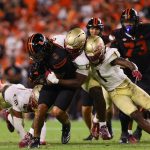 Oct 26, 2024; Miami Gardens, Florida, USA; Miami Hurricanes running back Damien Martinez (6) runs with the football against Florida State Seminoles defensive lineman KJ Sampson (56) and defensive back Shyheim Brown (1) during the fourth quarter at Hard Rock Stadium. Mandatory Credit: Sam Navarro-Imagn Images