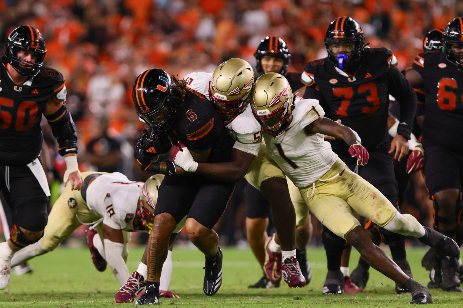 Oct 26, 2024; Miami Gardens, Florida, USA; Miami Hurricanes running back Damien Martinez (6) runs with the football against Florida State Seminoles defensive lineman KJ Sampson (56) and defensive back Shyheim Brown (1) during the fourth quarter at Hard Rock Stadium. Mandatory Credit: Sam Navarro-Imagn Images