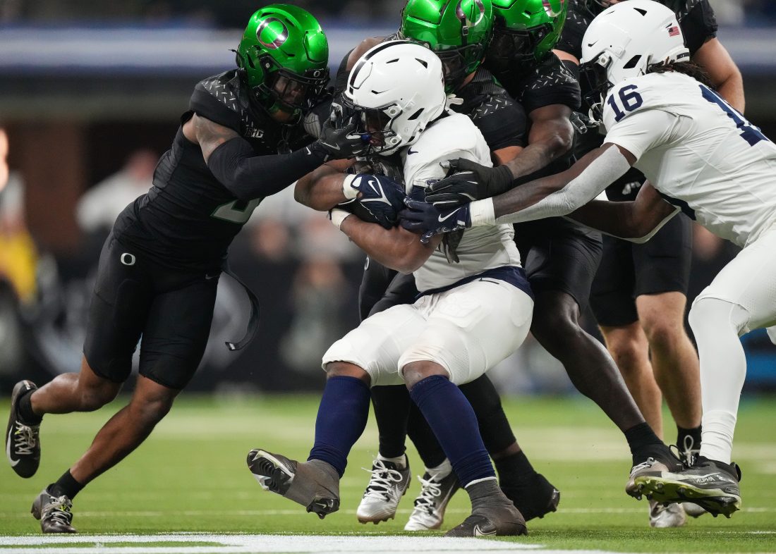 Penn State Nittany Lions running back Kaytron Allen (13) is stopped by Oregon Ducks defensive back Nikko Reed (9) on Saturday, Dec. 7, 2024, during the Big Ten Championship game at Lucas Oil Stadium in Indianapolis.