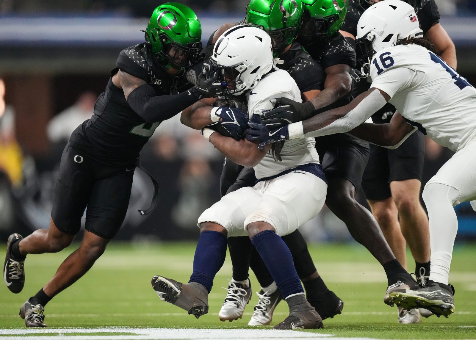 Penn State Nittany Lions running back Kaytron Allen (13) is stopped by Oregon Ducks defensive back Nikko Reed (9) on Saturday, Dec. 7, 2024, during the Big Ten Championship game at Lucas Oil Stadium in Indianapolis.