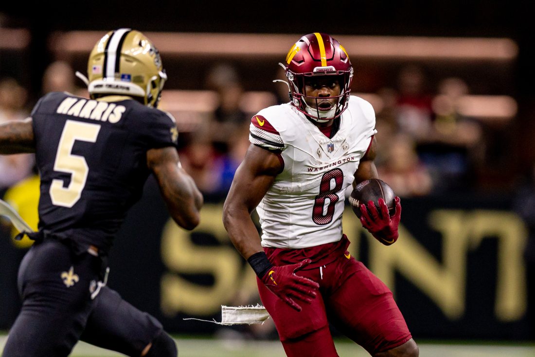 Dec 15, 2024; New Orleans, Louisiana, USA; Washington Commanders running back Brian Robinson Jr. (8) rushes against New Orleans Saints cornerback Will Harris (5) during the first half at Caesars Superdome. Mandatory Credit: Stephen Lew-Imagn Images
