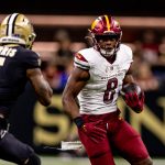 Dec 15, 2024; New Orleans, Louisiana, USA; Washington Commanders running back Brian Robinson Jr. (8) rushes against New Orleans Saints cornerback Will Harris (5) during the first half at Caesars Superdome. Mandatory Credit: Stephen Lew-Imagn Images