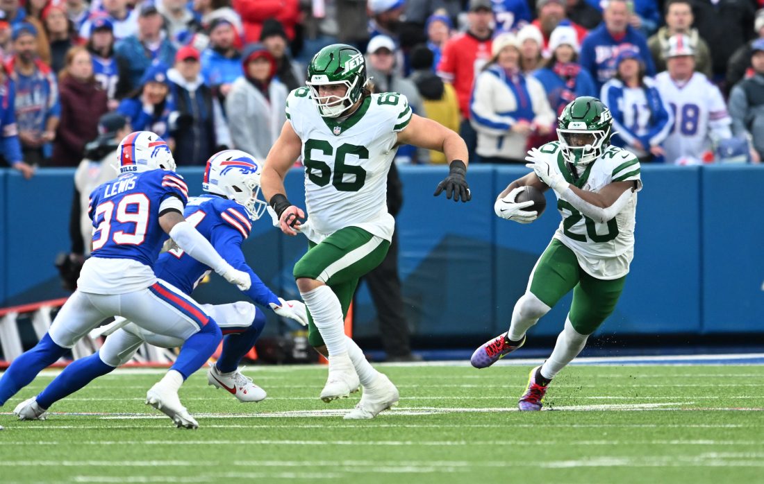 Dec 29, 2024; Orchard Park, New York, USA; New York Jets center Joe Tippmann (66) leads a block for running back Breece Hall (20) as Buffalo Bills cornerback Cam Lewis (39) tries to make a tackle in the fourth quarter at Highmark Stadium. Mandatory Credit: Mark Konezny-Imagn Images