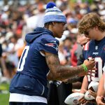 Aug 6, 2025; Foxborough, MA, USA; New England Patriots cornerback Christian Gonzalez (0) signs autographs at training camp at Gillette Stadium. Mandatory Credit: Eric Canha-Imagn Images