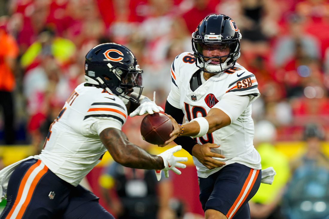 Aug 22, 2025; Kansas City, Missouri, USA; Chicago Bears quarterback Caleb Williams (18) hands off to running back D'Andre Swift (4) during the first half against the Kansas City Chiefs at GEHA Field at Arrowhead Stadium. Mandatory Credit: Jay Biggerstaff-Imagn Images