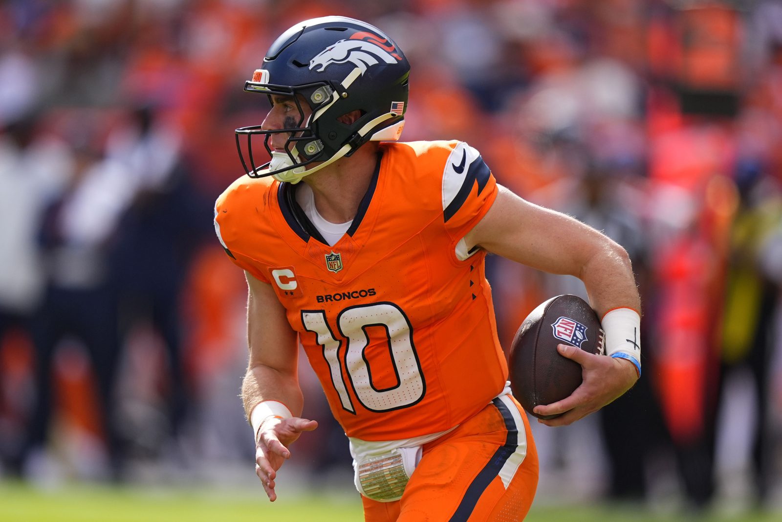Sep 7, 2025; Denver, Colorado, USA; Denver Broncos quarterback Bo Nix (10) rushes the ball against the Tennessee Titans in the second half at Empower Field at Mile High.
