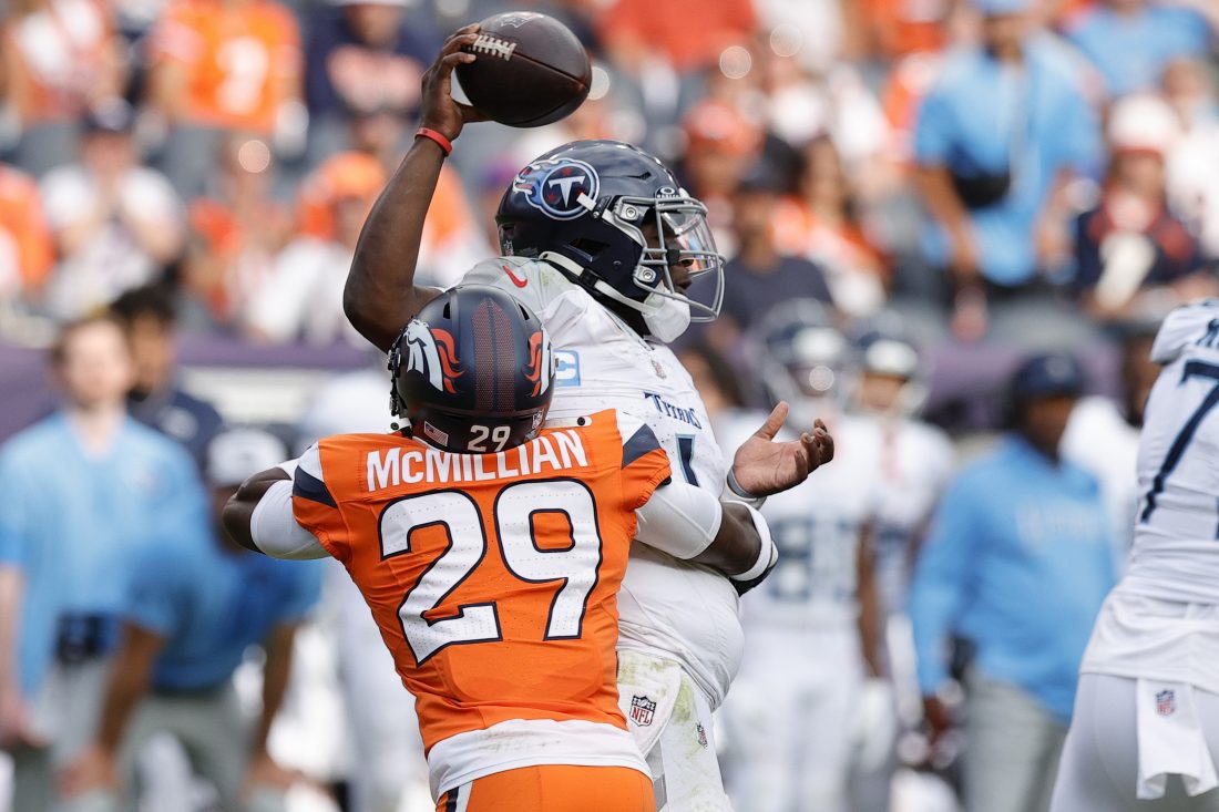 Sep 7, 2025; Denver, Colorado, USA; Denver Broncos cornerback Ja'Quan McMillian (29) hits Tennessee Titans quarterback Cam Ward (1) causing a fumble in the second half at Empower Field at Mile High. Mandatory Credit: Isaiah J. Downing-Imagn Images