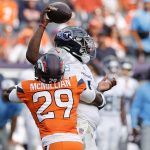 Sep 7, 2025; Denver, Colorado, USA; Denver Broncos cornerback Ja'Quan McMillian (29) hits Tennessee Titans quarterback Cam Ward (1) causing a fumble in the second half at Empower Field at Mile High. Mandatory Credit: Isaiah J. Downing-Imagn Images