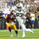 Sep 11, 2025; Green Bay, Wisconsin, USA; Green Bay Packers wide receiver Romeo Doubs (87) scores a touchdown against Washington Commanders cornerback Mike Sainristil (0) in the first quarter at Lambeau Field. Mandatory Credit: Jeff Hanisch-Imagn Images