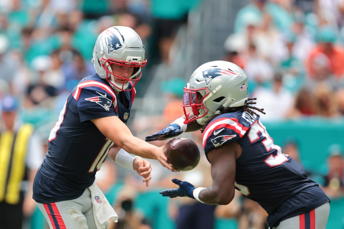 Sep 14, 2025; Miami Gardens, Florida, USA; New England Patriots running back Rhamondre Stevenson (38) takes a handoff from quarterback Drake Maye (10) against the Miami Dolphins during the third quarter at Hard Rock Stadium. Mandatory Credit: Sam Navarro-Imagn Images
