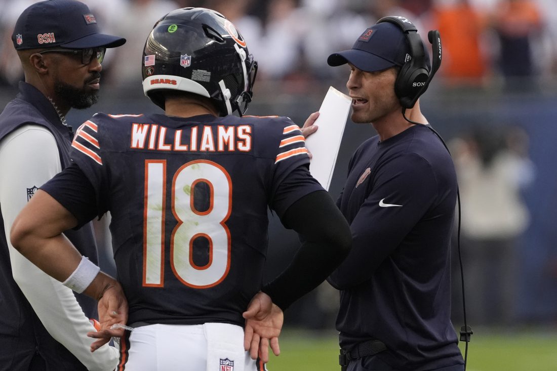 Sep 21, 2025; Chicago, Illinois, USA; Chicago Bears head coach Ben Johnson talks with quarterback Caleb Williams (18) against the Dallas Cowboys during the second half at Soldier Field.