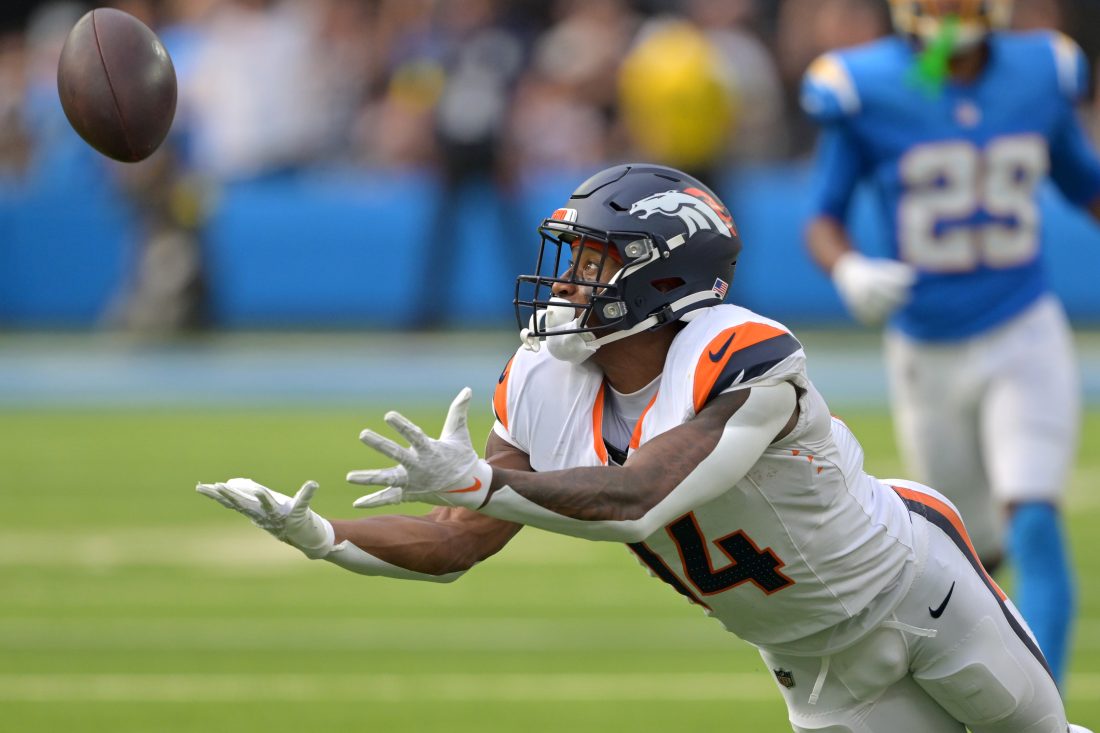 Sep 21, 2025; Inglewood, California, USA; Denver Broncos wide receiver Courtland Sutton (14) reaches for a long pass 4th down in the second half against the Los Angeles Chargers at SoFi Stadium.