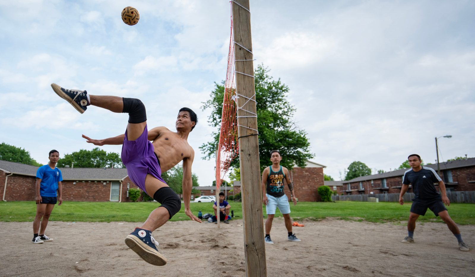 Ma Ling kicks the ball while playing sepak takraw Sunday, May 14, 2023, with friends on a dirt court in Southport. Sepak takraw brings the Burmese American community closer together in Indianapolis as they play the national sport of Burma.