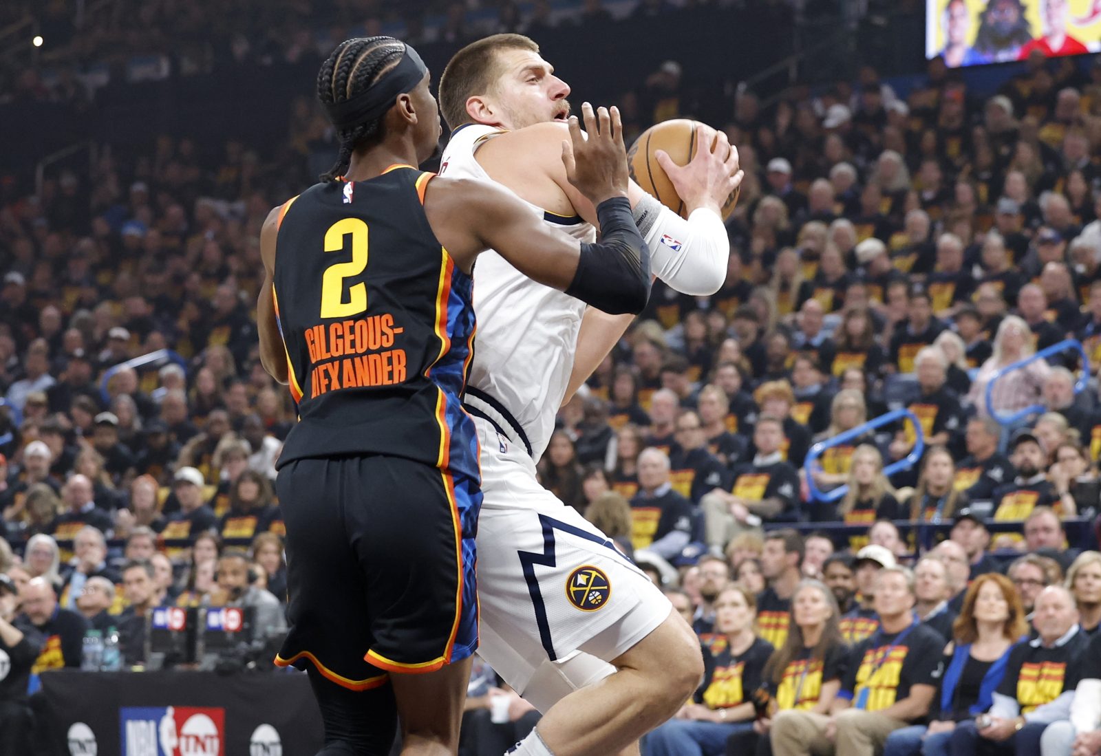 May 5, 2025; Oklahoma City, Oklahoma, USA; Denver Nuggets center Nikola Jokic (15) drives against Oklahoma City Thunder guard Shai Gilgeous-Alexander (2) during the first quarter in game one of the second round for the 2025 NBA Playoffs at Paycom Center.