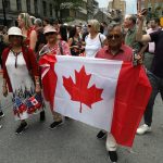 People take part in a parade in Old Montreal on Canada Day, July 1, 2025. A surge in Canadian patriotism has driven up sales of red-and-white Canadian flags, patches and lapel pins and spawned a demand for hats and T-shirts with slogans like “Canada Is Not For Sale.”
