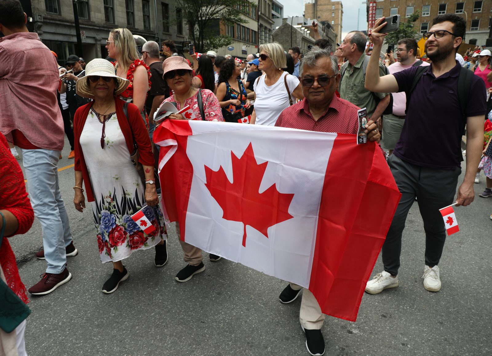 People take part in a parade in Old Montreal on Canada Day, July 1, 2025. A surge in Canadian patriotism has driven up sales of red-and-white Canadian flags, patches and lapel pins and spawned a demand for hats and T-shirts with slogans like “Canada Is Not For Sale.”