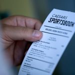 A man looks at his ticket after placing a bet at the Caesars Sportsbook betting window at Chase Field in Phoenix on the first day of sports betting on September 9, 2021. Chase Field is the first major league stadium to have sports betting.
