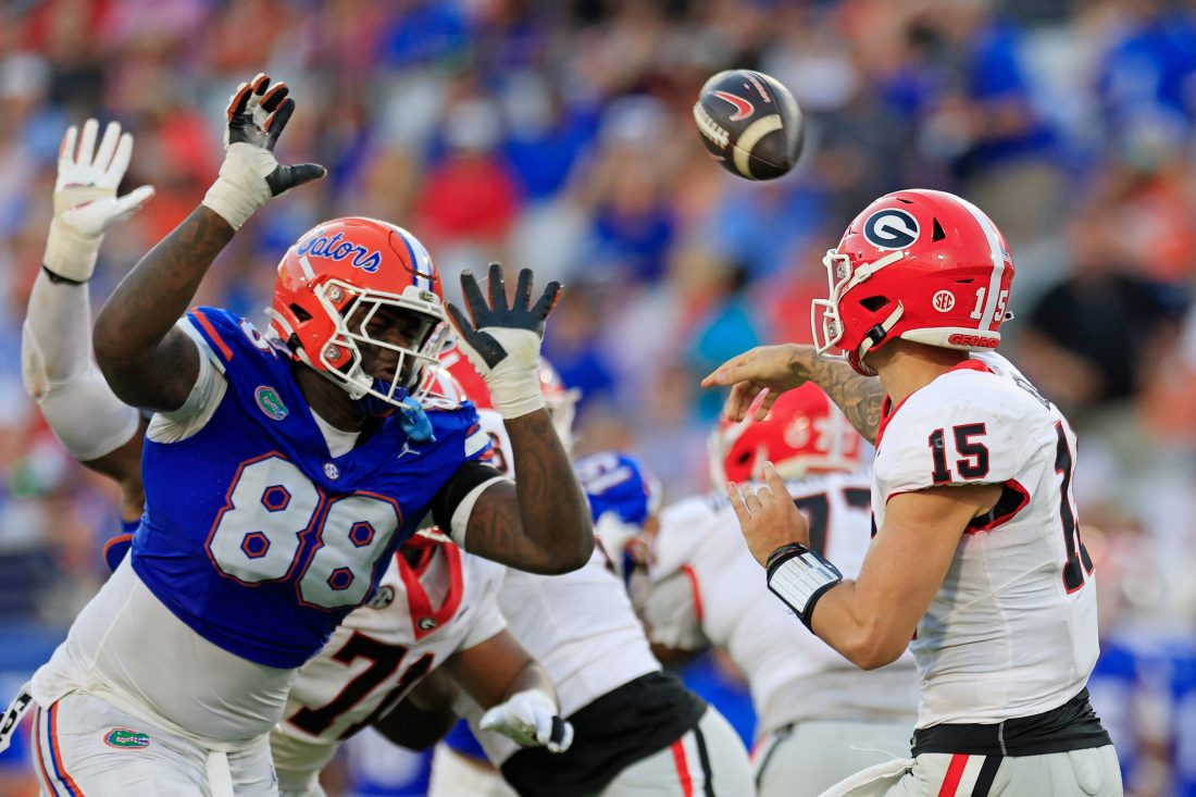 Georgia Bulldogs quarterback Carson Beck (15) is pressured by Florida Gators defensive lineman Caleb Banks (88) during the third quarter of an NCAA football game Saturday, Oct. 28, 2023 at EverBank Stadium in Jacksonville, Fla. Georgia defeated Florida 43-20.
