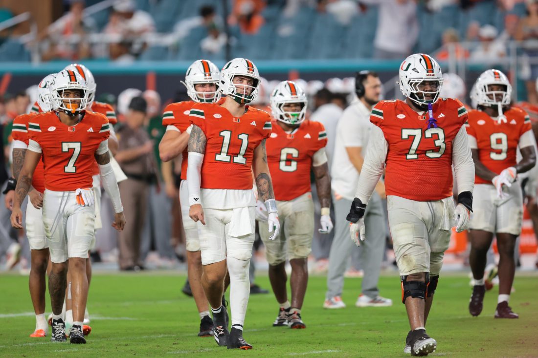 Sep 20, 2025; Miami Gardens, Florida, USA; Miami Hurricanes quarterback Carson Beck (11) and his teammates walk toward the line of scrimmage against the Florida Gators during the fourth quarter at Hard Rock Stadium. Mandatory Credit: Sam Navarro-Imagn Images