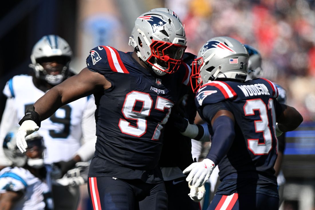 Sep 28, 2025; Foxborough, Massachusetts, USA; New England Patriots defensive end Milton Williams (97) and safety Craig Woodson (31) react after making at tackle against the Carolina Panthers during the first half at Gillette Stadium. Mandatory Credit: Brian Fluharty-Imagn Images