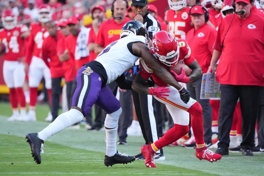 Sep 28, 2025; Kansas City, Missouri, USA; Kansas City Chiefs wide receiver Hollywood Brown (5) runs after making a catch as Baltimore Ravens cornerback Chidobe Awuzie (3) defends during the first half at GEHA Field at Arrowhead Stadium.