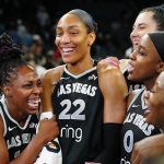 Sep 30, 2025; Las Vegas, Nevada, USA; Las Vegas Aces guard Chelsea Gray (12), Las Vegas Aces center A'ja Wilson (22), and Las Vegas Aces guard Jackie Young (0) react during an interview after defeating the Indiana Fever 107-98 in overtime of game five of the second round for the 2025 WNBA Playoffs at Michelob Ultra Arena.
