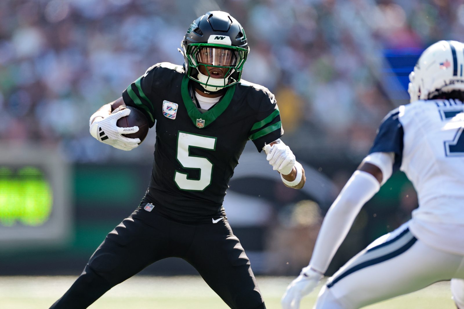 Oct 5, 2025; East Rutherford, New Jersey, USA; New York Jets wide receiver Garrett Wilson (5) carries the ball after the catch against the Dallas Cowboys during the first half at MetLife Stadium. Mandatory Credit: Vincent Carchietta-Imagn Images