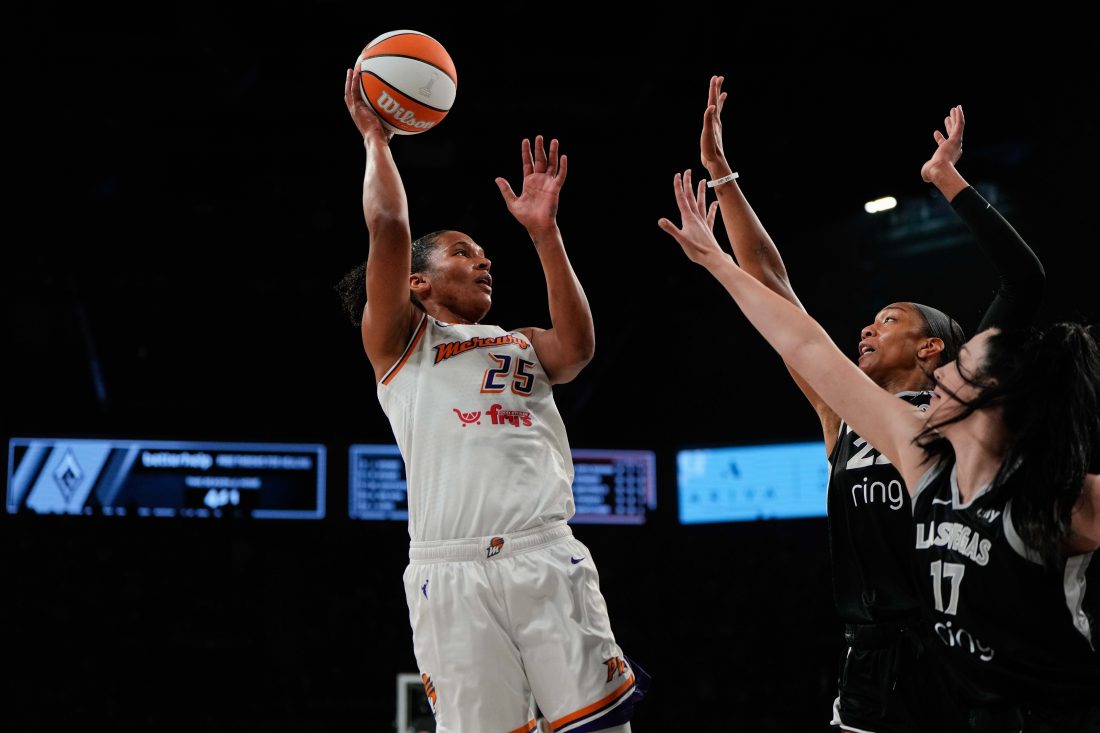 Oct 5, 2025; Las Vegas, Nevada, USA; Phoenix Mercury forward Alyssa Thomas (25) shoots the ball against Las Vegas Aces centers A'ja Wilson (22) and Megan Gustafson (17) during the first quarter of game two of the 2025 WNBA Finals at Michelob Ultra Arena.