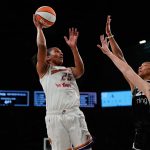 Oct 5, 2025; Las Vegas, Nevada, USA; Phoenix Mercury forward Alyssa Thomas (25) shoots the ball against Las Vegas Aces centers A'ja Wilson (22) and Megan Gustafson (17) during the first quarter of game two of the 2025 WNBA Finals at Michelob Ultra Arena.