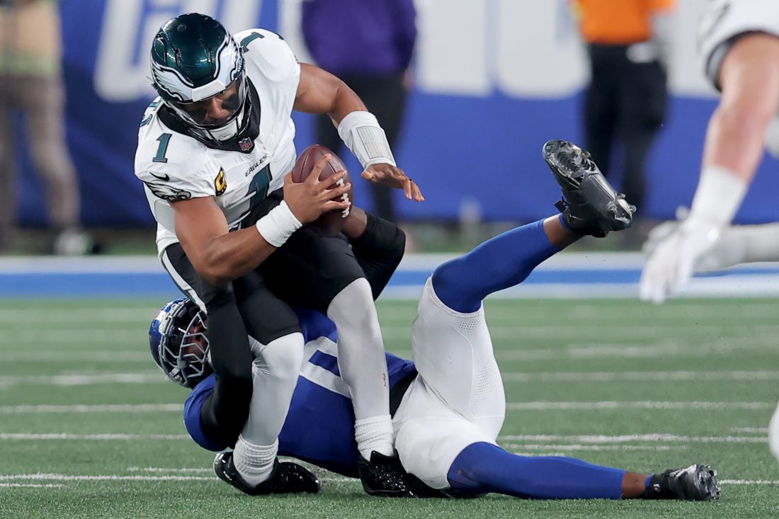 Oct 9, 2025; East Rutherford, New Jersey, USA; New York Giants linebacker Brian Burns (0) sacks Philadelphia Eagles quarterback Jalen Hurts (1) during the third quarter at MetLife Stadium. Mandatory Credit: Brad Penner-Imagn Images