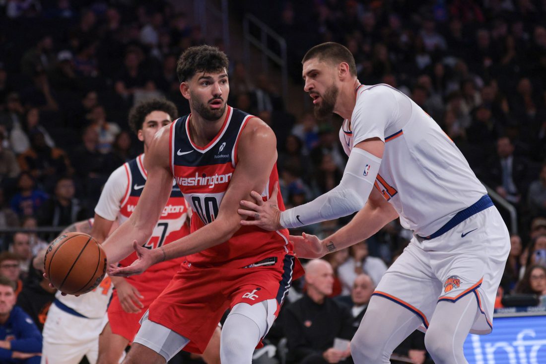 Oct 13, 2025; New York, New York, USA; Washington Wizards forward Tristan Vukcevic (00) looks to pass asNew York Knicks center Alex Len (21) defends during the first half at Madison Square Garden. Mandatory Credit: Vincent Carchietta-Imagn Images
