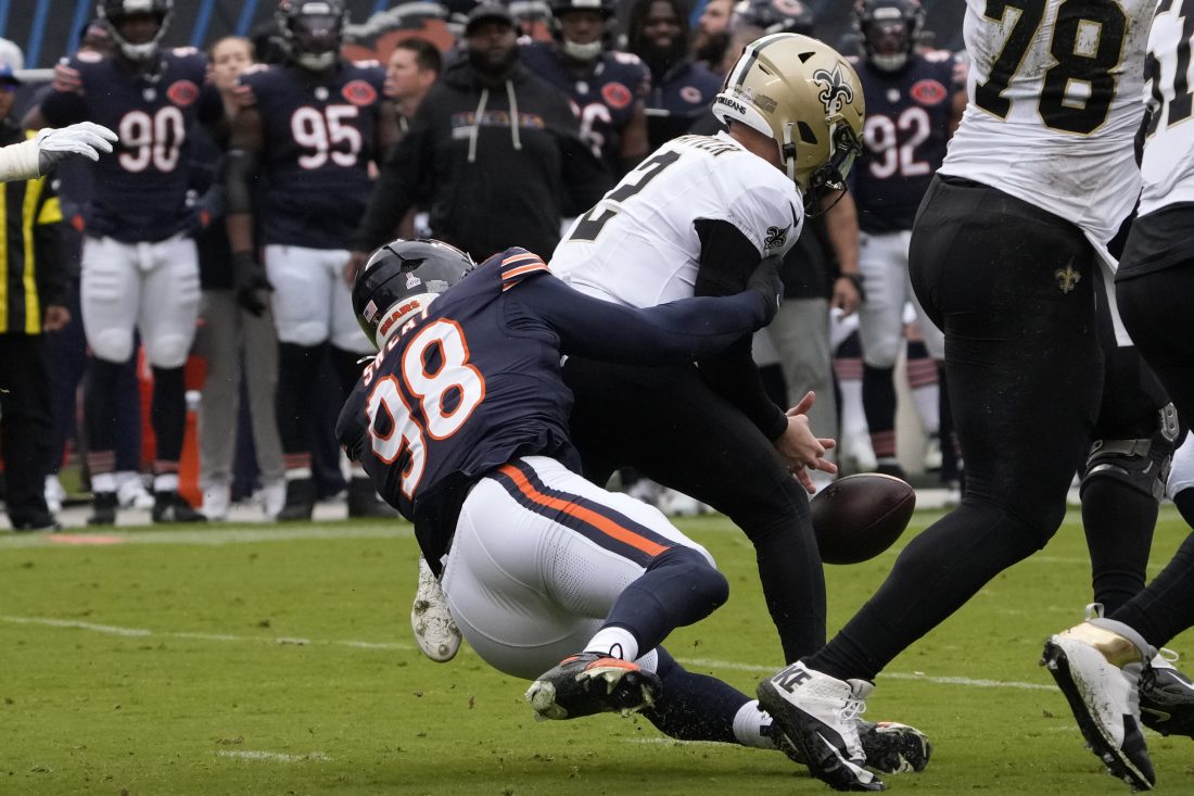 Oct 19, 2025; Chicago, Illinois, USA; New Orleans Saints quarterback Spencer Rattler (2) fumbles the ball on a sack by Chicago Bears defensive end Montez Sweat (98) during the first half at Soldier Field. Mandatory Credit: David Banks-Imagn Images