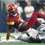 Oct 19, 2025; Arlington, Texas, USA; Washington Commanders quarterback Jayden Daniels (5) fumbles the ball defended by Dallas Cowboys linebacker Shemar James (50) during the third quarter of the game at AT&T Stadium. Mandatory Credit: Kevin Jairaj-Imagn Images
