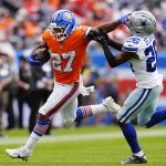 Oct 26, 2025; Denver, Colorado, USA; Denver Broncos running back J.K. Dobbins (27) runs against Dallas Cowboys cornerback DaRon Bland (26) in the first half at Empower Field at Mile High. Mandatory Credit: Ron Chenoy-Imagn Images