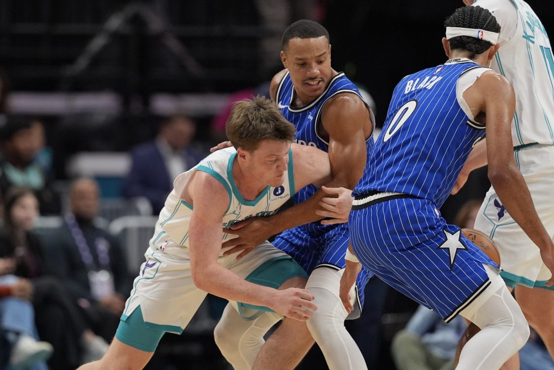 Oct 30, 2025; Charlotte, North Carolina, USA; Charlotte Hornets guard Kon Knueppel (7) and Orlando Magic guard Desmond Bane (3) fight for possession during the first quarter at Spectrum Center. Mandatory Credit: Jim Dedmon-Imagn Images