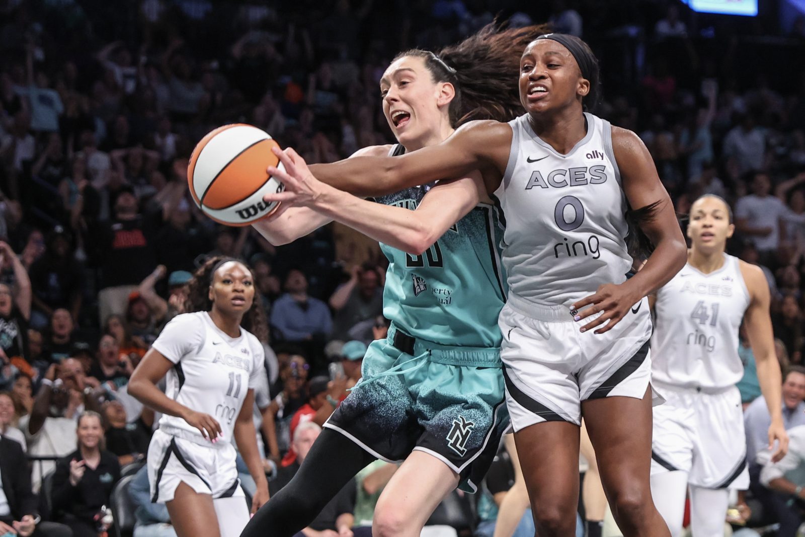 Jul 8, 2025; Brooklyn, New York, USA; New York Liberty forward Breanna Stewart (30) and Las Vegas Aces guard Jackie Young (0) fight for a loose ball in the third quarter at Barclays Center.
