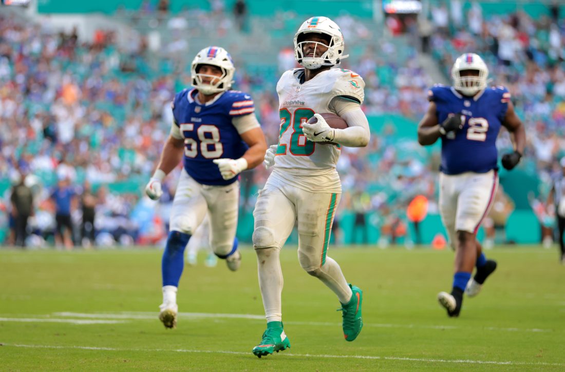 Nov 9, 2025; Miami Gardens, Florida, USA; Miami Dolphins running back De'Von Achane (28) runs for a touchdown against Buffalo Bills linebacker Matt Milano (58) during the second half at Hard Rock Stadium. Mandatory Credit: Sam Navarro-Imagn Images