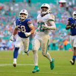 Nov 9, 2025; Miami Gardens, Florida, USA; Miami Dolphins running back De'Von Achane (28) runs for a touchdown against Buffalo Bills linebacker Matt Milano (58) during the second half at Hard Rock Stadium. Mandatory Credit: Sam Navarro-Imagn Images