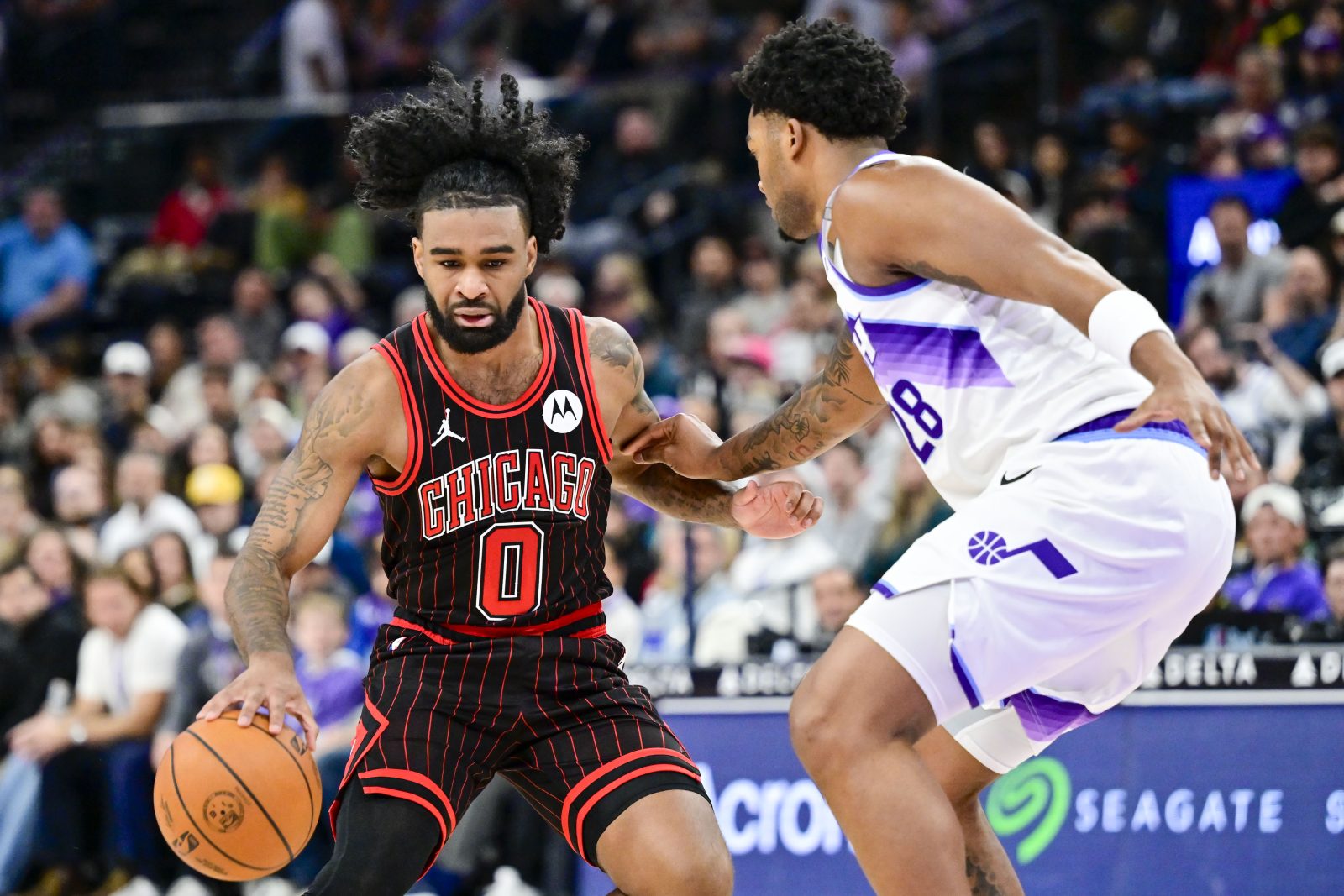 Nov 16, 2025; Salt Lake City, Utah, USA; Chicago Bulls guard Coby White (0) plans his next move against Utah Jazz forward Brice Sensabaugh (28) during the second half at Delta Center. Mandatory Credit: Peter Creveling-Imagn Images