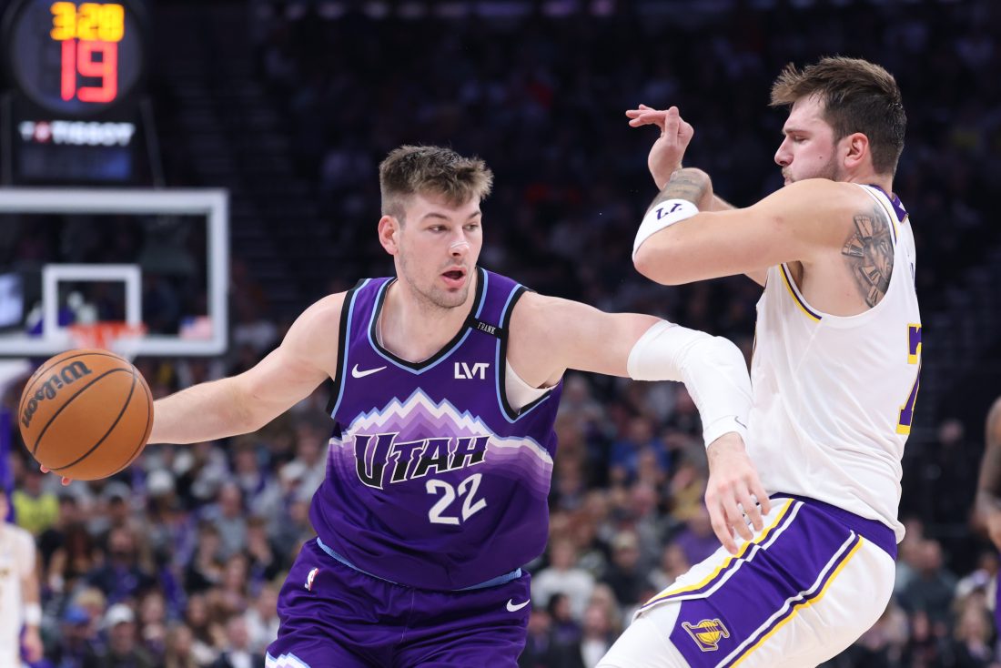 Nov 23, 2025; Salt Lake City, Utah, USA; Utah Jazz forward Kyle Filipowski (22) drives against Los Angeles Lakers guard Luka Doncic (77) during the second half at Delta Center. Mandatory Credit: Rob Gray-Imagn Images